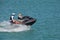 Man and a Woman riding tandem on a speeding jetski.