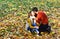 Man and woman with romantic faces on autumn trees background