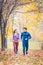 Man and woman running as fitness sport in an autumn park