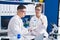 Man and woman scientists holding test tubes at laboratory