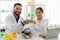 Man and woman scientists smiling confident bump fists at laboratory