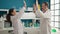 Man and woman scientists working high five with hands raised up at laboratory