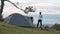 Man and woman setting up a tent in a beautiful camping spot in the mountain.