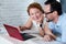 Man and woman sharing earphones while lying on bed