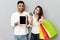 Man and woman showing credit card and tablet with empty screen