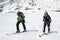 Man and woman ski mountaineer climb on mountain on skis strapped to climbing skins