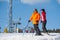 Man and woman skiers with skis at winter resort
