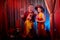 Man and woman with small dor on the theater stage. Photo shoot in the circus style with girl, boy and pet