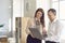 Man and woman smiling discussing work moments in front of laptop in friendly atmosphere.