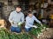 Man and woman sort green onions in vegetable store