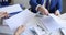 Man and woman sorting documents with stapler and hole punch and folding into folders 4k movie slow motion