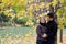 Man and woman stand embracing under maple tree in