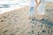 Man and woman stand on the sand holding hands. Cropped