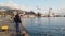 Man and woman stand on the seashore and feed birds