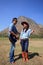 Man and woman standing in farm field playing guitar and dancing