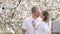 Man and woman standing near flowering tree in spring