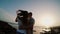 Man and woman standing on the shore by the sea, hugging and watching on sunset. Couple on evening beach. Slow motions.