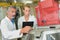 Man and woman stood by machine in factory