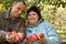 Man and woman stretch out their hands with apples