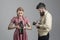 Man and woman on strict faces on grey background. Vintage photography concept. Man in checkered clothes, retro style