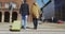 Man and woman with suitcase crossing the road