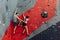 Man and woman supporting each other at bouldering course.