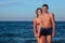 Man and woman in swimsuits stand in water