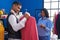 Man and woman tailor and customer choosing jacket at sewing studio