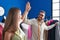 Man and woman tailors high five with hands raised up at clothing factory
