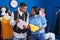 Man and woman tailors holding cloth reading document at sewing studio