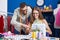 Man and woman tailors smiling confident using sewing machine at clothing factory