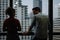 Man and Woman talking together near large glass window of office building