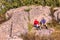 Man and woman tourists are sitting under a rock are resting after a good walk in the Ural mountains
