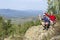 Man and woman tourists stand on the top of the mountain against the background of the Ural mountains and taiga