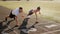 A man and a woman train with dumbbells at the stadium in the summer.