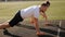 A man and a woman train with dumbbells at the stadium in the summer.