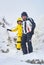 Man and woman travelers descend from the snowy top of the mountain