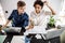 Man and woman using laptops in modern coworking space