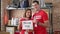 Man and woman volunteers standing together holding paper with thank you message at charity center