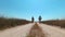 A man and a woman walk along the road on Kinburn Spit on a hot summer day