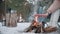 Man and woman warming their hands by a campfire in the woods in winter