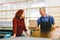 Man and woman working on glass pane in glazier workshop