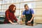 Man and woman working on glass pane in glazier workshop