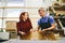 Man and woman working on glass pane in glazier workshop