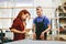 Man and woman working on glass pane in glazier workshop