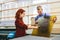 Man and woman working on glass pane in glazier workshop