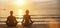 Man and woman yoga silhouettes meditating on Sea coast.