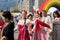 Man and women in Russian national costumes have fun and dance in the city square