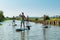 Man and women stand up paddleboarding