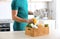 Man with wooden crate full of products and tablet. Food delivery service